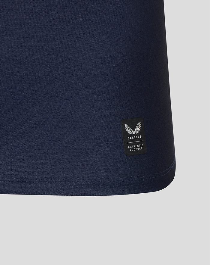Close up of navy jersey sleeve showing a red crest patch with a white dragon emblem