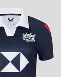 Detail view of the navy jersey collar and chest with white dragon crest bold diamond sponsor graphic and red shoulder patch.