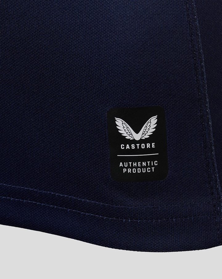 Navy jersey hem close up featuring a black Castore authentic product patch