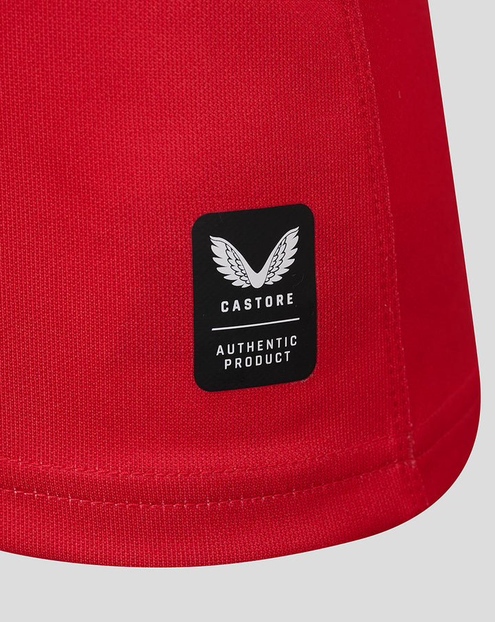 Close up of the red jersey hem showing a Castore authentic product patch