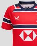 Close-up of shoulder and neckline of red HKCR away jersey with Castore branding and navy trim