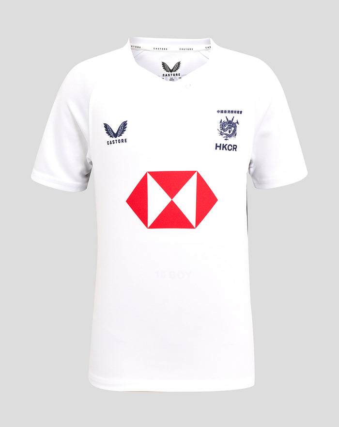 Front view of white junior away replica rugby jersey with Castore logo on left chest, HKCR crest on the right chest, and a red central sponsor emblem.