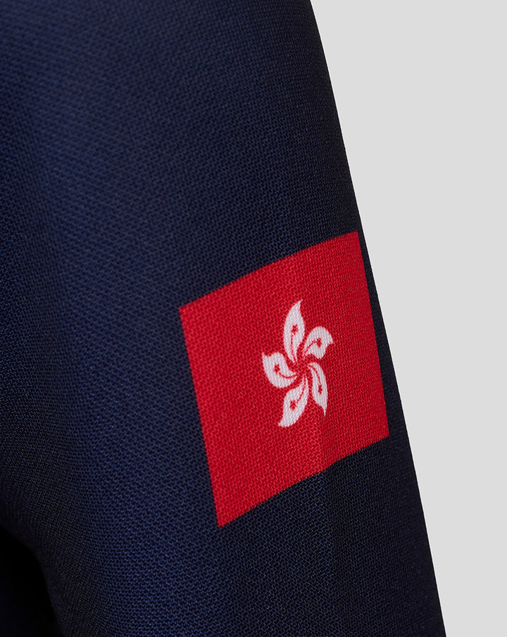 Close-up of the navy jersey sleeve with a red flag patch bearing a white fleur de lis emblem.