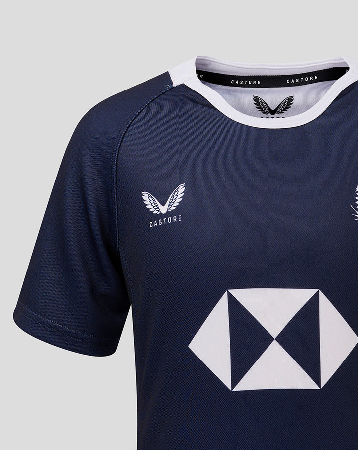 Navy jersey chest area with a small white crest and a large white geometric sponsor logo