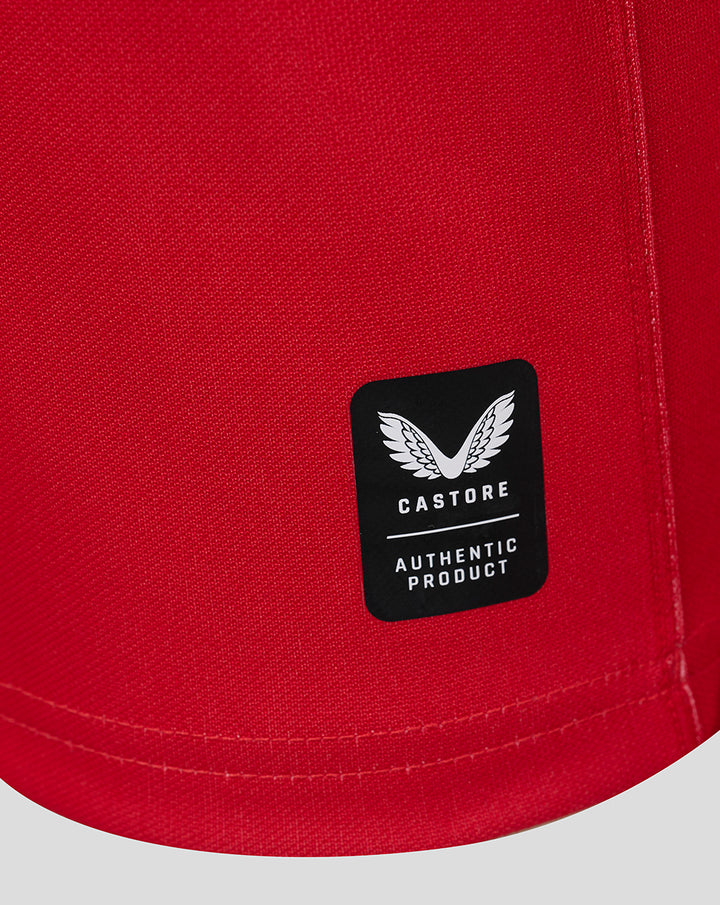 Close-up of red jersey fabric with Castore authentic product label on the hem