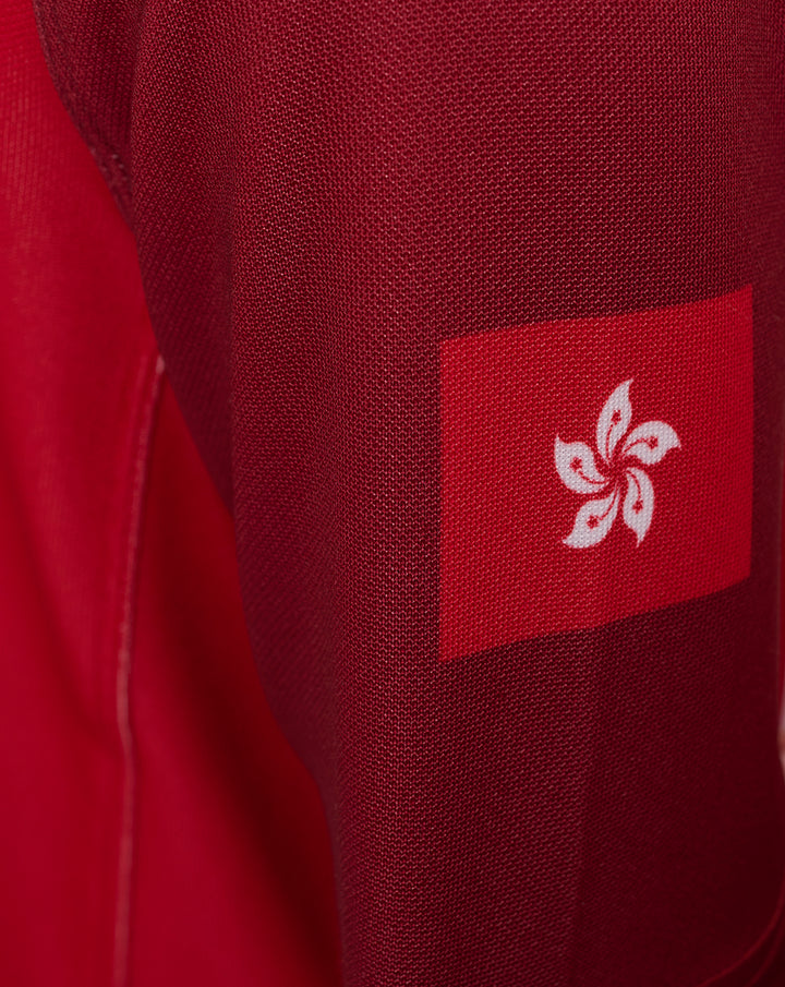 Close up of the sleeve showing a red patch with a white fleur-de-lis emblem on red fabric