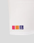 Hem of white junior rugby tee showing pink orange and purple color blocks with a wheelchair symbol on the purple block.