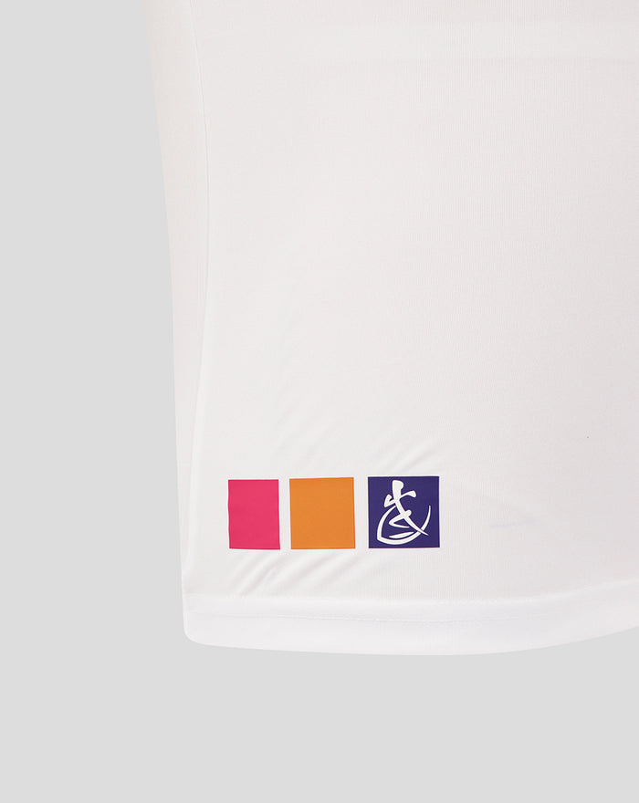 Hem of white junior rugby tee showing pink orange and purple color blocks with a wheelchair symbol on the purple block.