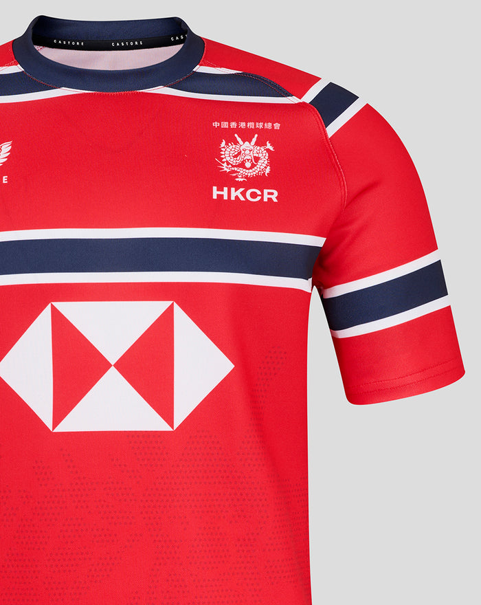 Close up of red HKCR Away 15s replica rugby jersey showing crest and white diamond sponsor logo with navy stripes