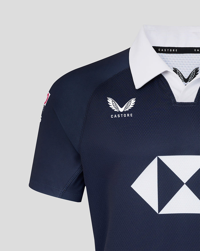 Close-up of navy jersey showing white collar dragon crest and large white diamond sponsor logo on chest