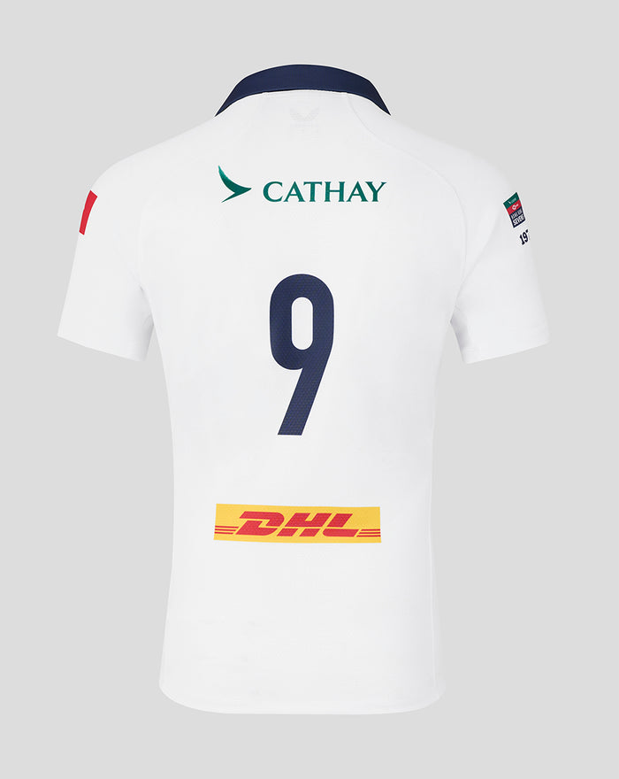 Back view of white HK7s jersey showing navy collar and large blue number 9 with sponsor logos and a dragon crest near the shoulder.