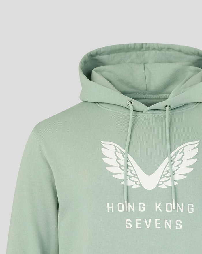 Aloe green unisex hoodie close-up shows oversized white wings graphic and Hong Kong Sevens text on the chest.