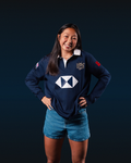 Junior model wearing navy HK7S Limited Edition long sleeve vintage rugby jersey with crest and white geometric logo